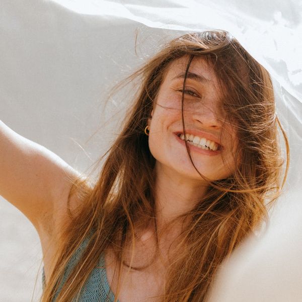 Smiling person outdoors feeling energetic and free.